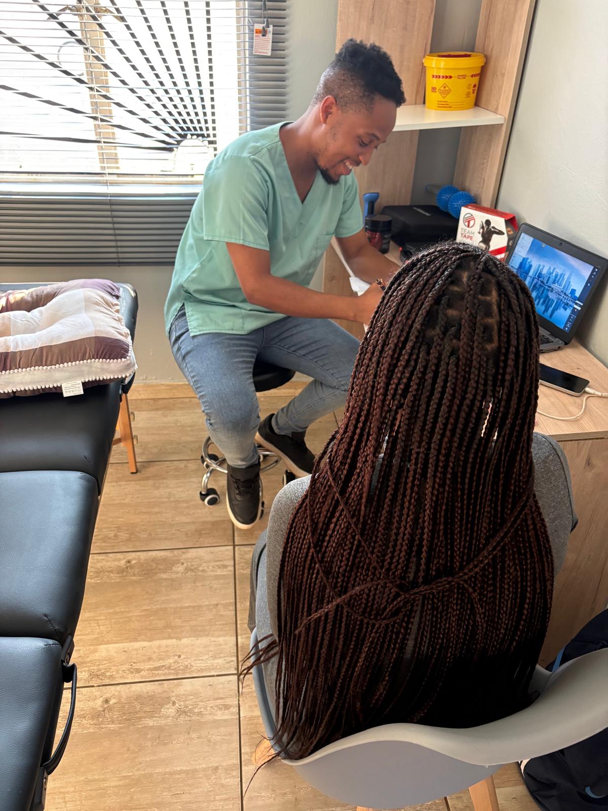Sipho writing up an assessment during a session
